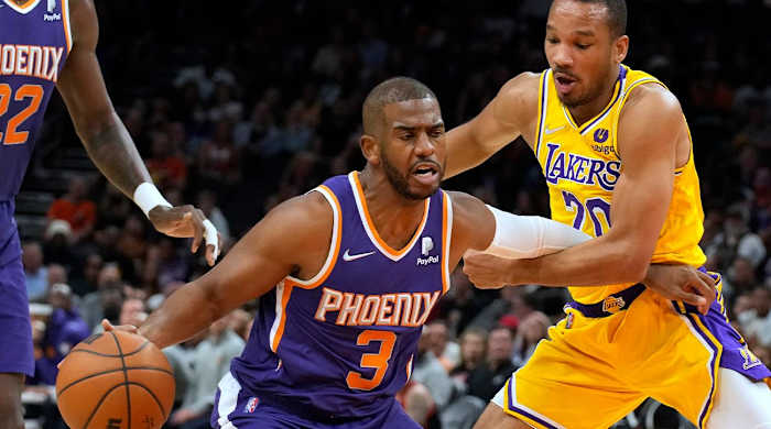 Los Angeles Lakers guard Avery Bradley fouls Phoenix Suns guard Chris Paul (3) during the second half of an NBA basketball game Tuesday, April 5, 2022, in Phoenix. The Suns won 121-110.
